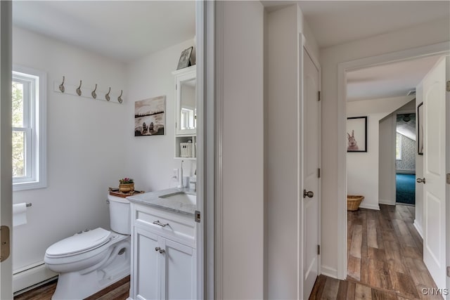 bathroom with baseboard heating, vanity, toilet, and hardwood / wood-style flooring