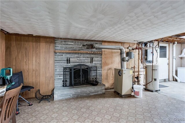 basement featuring a fireplace, wood walls, and gas water heater