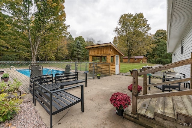 view of patio featuring a fenced in pool and an outdoor structure