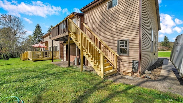 back of property featuring a wooden deck and a yard