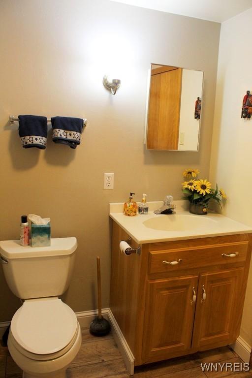 bathroom featuring hardwood / wood-style flooring, vanity, and toilet