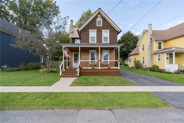 view of front of home with a front yard and covered porch