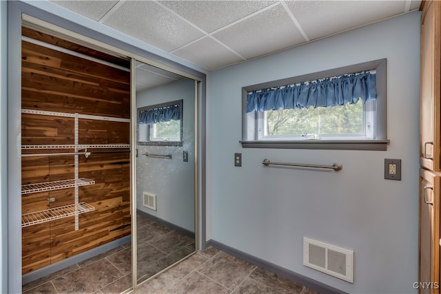 interior space with a drop ceiling and tile patterned floors