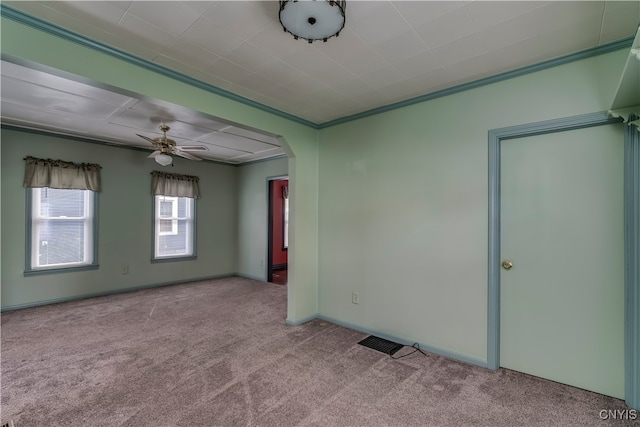 carpeted spare room featuring ceiling fan and ornamental molding