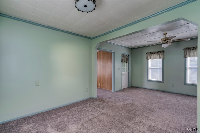 empty room featuring ceiling fan, light colored carpet, and crown molding