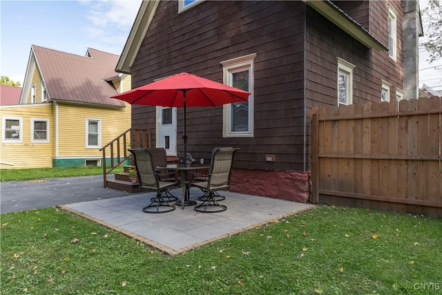 back of house featuring a lawn and a patio area