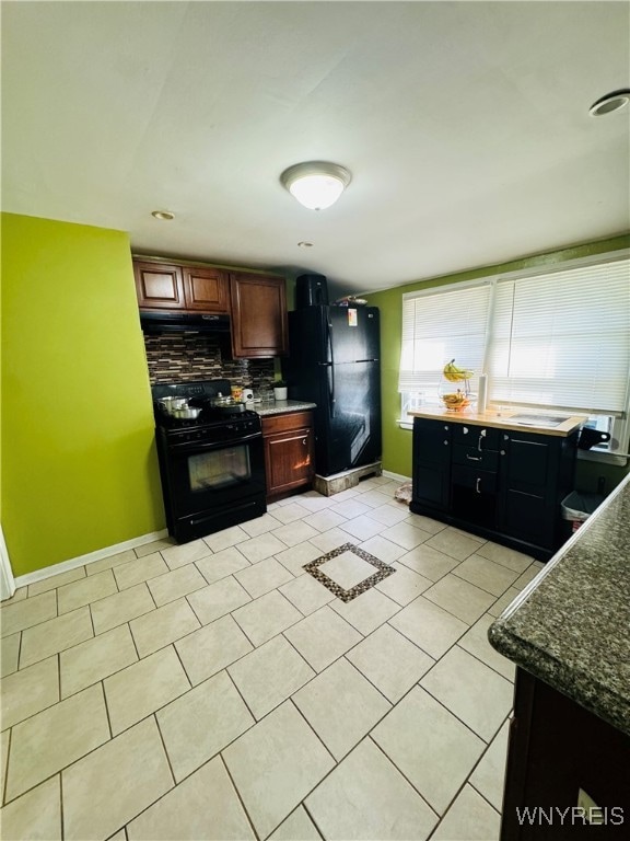 kitchen featuring light tile patterned flooring, backsplash, and black appliances