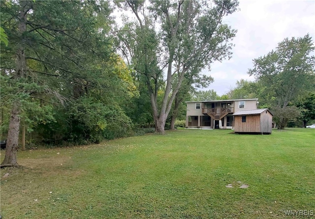 view of yard with a wooden deck and an outbuilding