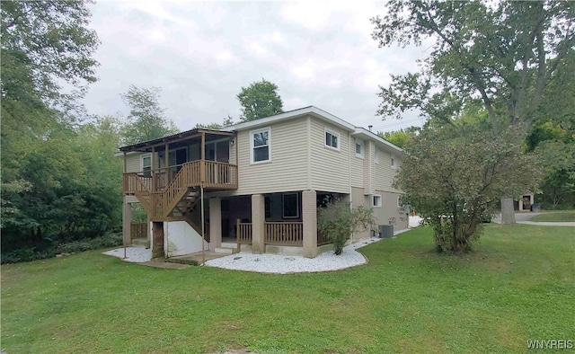 rear view of property with cooling unit, a lawn, and a deck