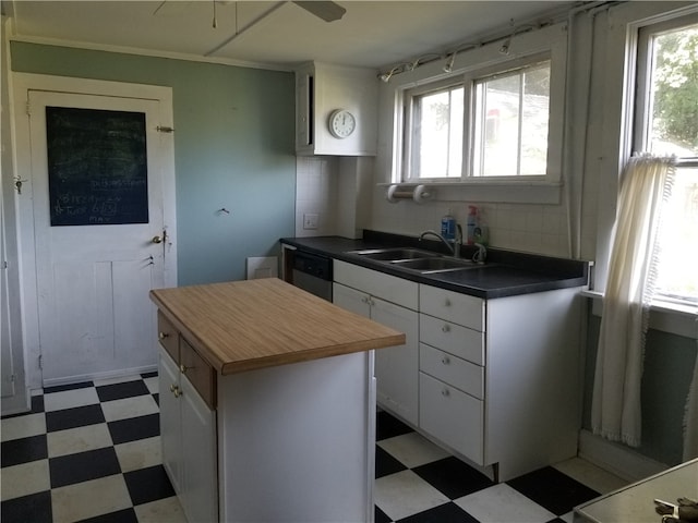 kitchen featuring white cabinets, sink, a healthy amount of sunlight, and a kitchen island