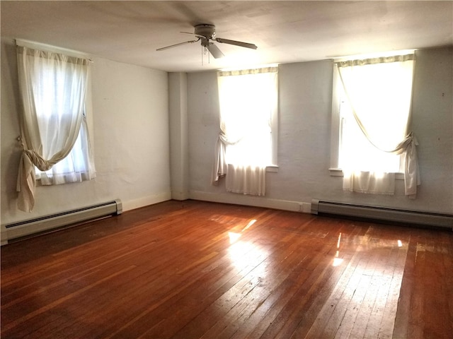 empty room with ceiling fan, baseboard heating, and dark wood-type flooring