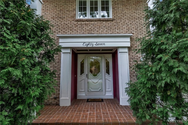 view of exterior entry featuring brick siding