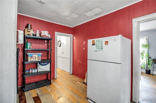 kitchen featuring hardwood / wood-style flooring, white fridge, and crown molding