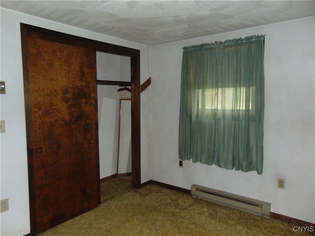 unfurnished bedroom featuring baseboard heating and carpet floors