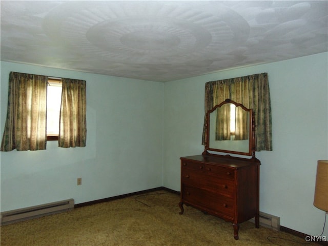 spare room featuring a baseboard radiator and light colored carpet