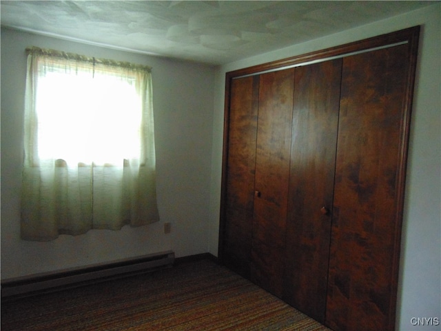 bedroom featuring a baseboard radiator and a closet