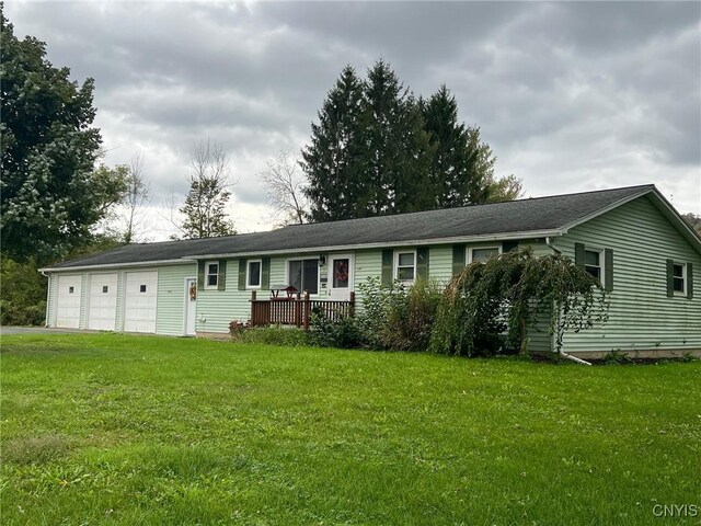 single story home with a front yard, a garage, and a wooden deck