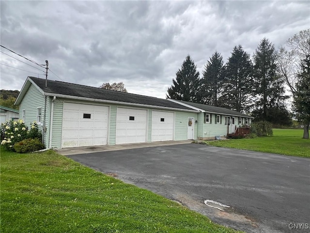 ranch-style home with a garage and a front lawn