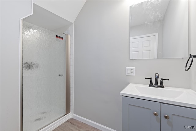 bathroom featuring walk in shower, vanity, and lofted ceiling