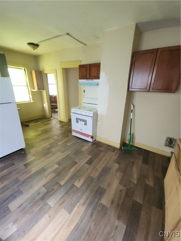 kitchen featuring dark wood-type flooring and white appliances