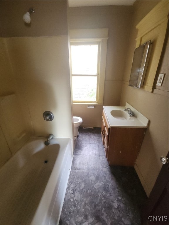 bathroom featuring a bathtub, vanity, and toilet