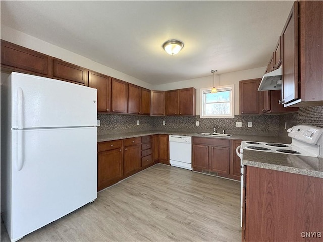 kitchen featuring backsplash, light hardwood / wood-style flooring, pendant lighting, and white appliances