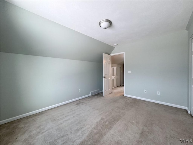 bonus room with carpet flooring and vaulted ceiling