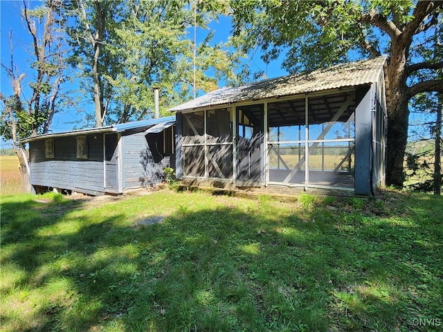 rear view of property featuring a lawn