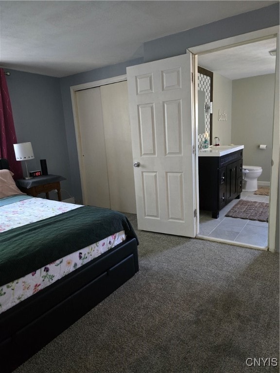 carpeted bedroom featuring ensuite bath and a closet