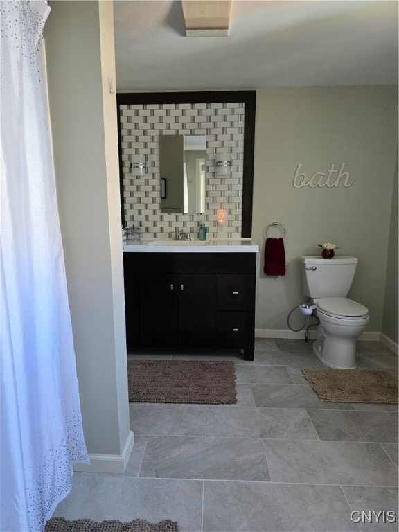 bathroom featuring toilet, vanity, and tasteful backsplash