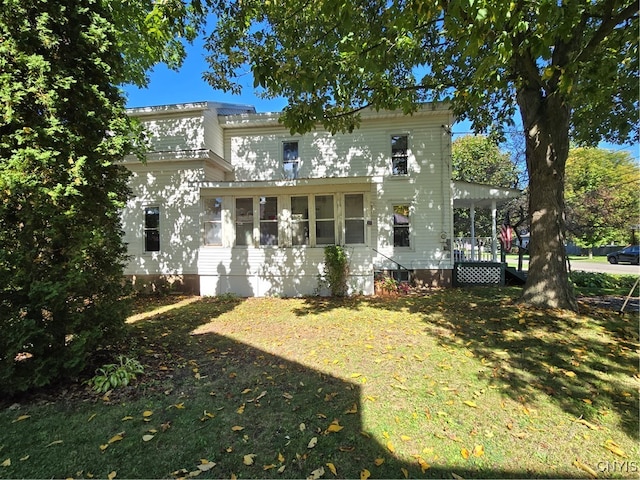 rear view of property featuring a lawn