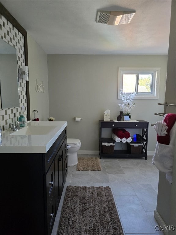 bathroom with vanity, tile patterned flooring, toilet, and tasteful backsplash