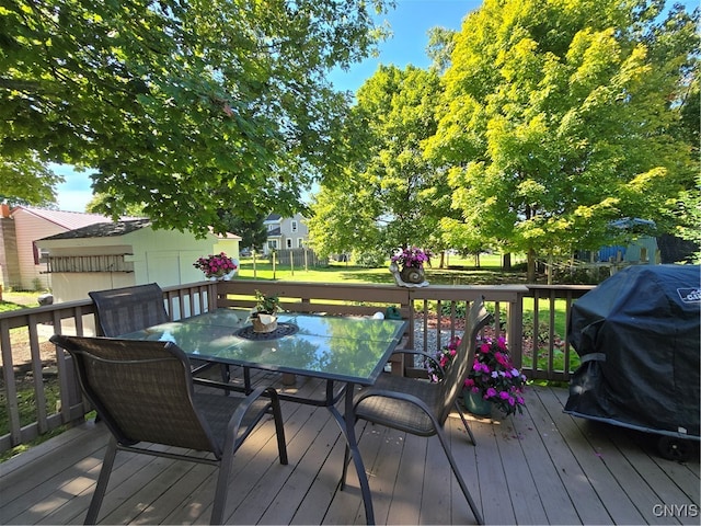 wooden deck with area for grilling and a yard