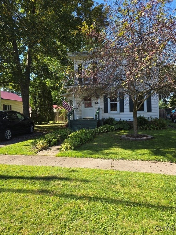 obstructed view of property with a front yard