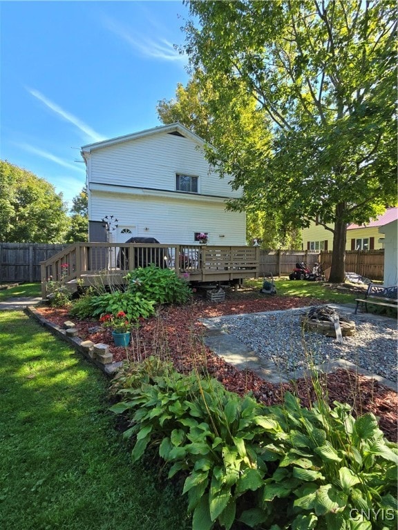 rear view of property with a wooden deck and a lawn