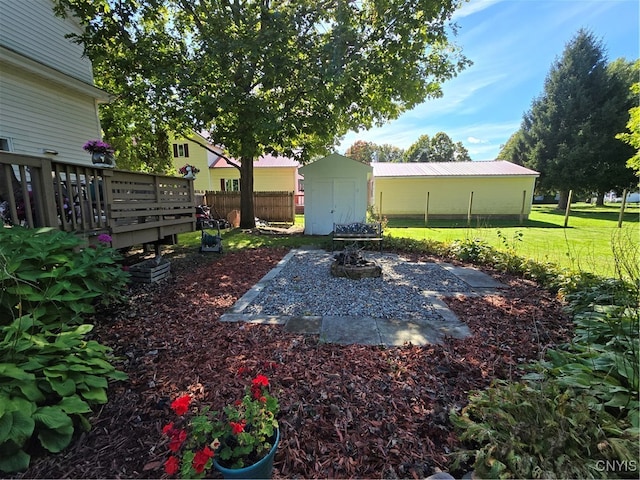 view of yard featuring a storage unit and a wooden deck