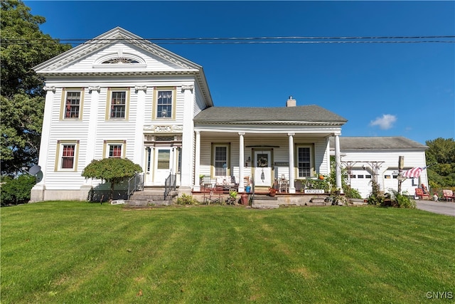 neoclassical / greek revival house featuring a front yard and covered porch