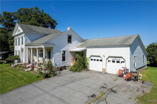 view of front of property with a garage, covered porch, and a front yard