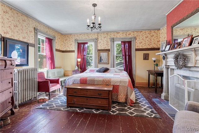 bedroom featuring multiple windows, radiator, dark hardwood / wood-style floors, and a chandelier