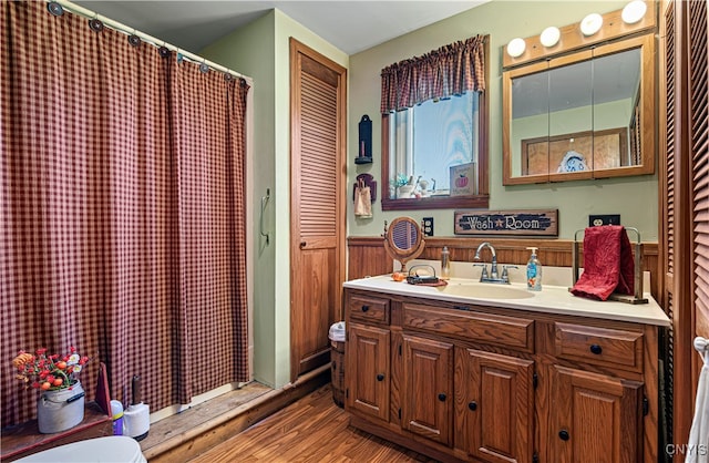 bathroom featuring wood walls, vanity, walk in shower, hardwood / wood-style flooring, and toilet