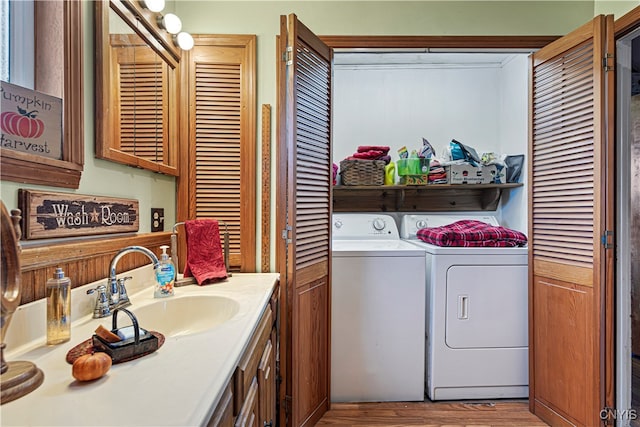 laundry area with sink, light hardwood / wood-style flooring, and independent washer and dryer