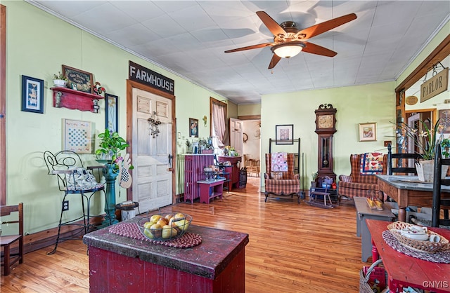 living room with crown molding, ceiling fan, and hardwood / wood-style flooring