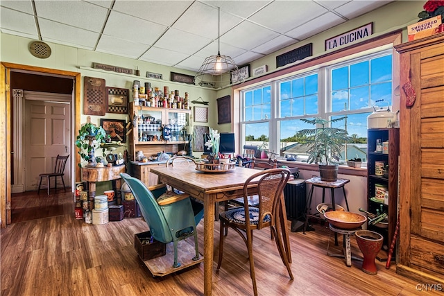 dining area featuring hardwood / wood-style flooring and a paneled ceiling