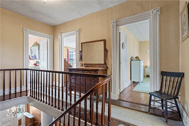 hall featuring a notable chandelier and hardwood / wood-style flooring