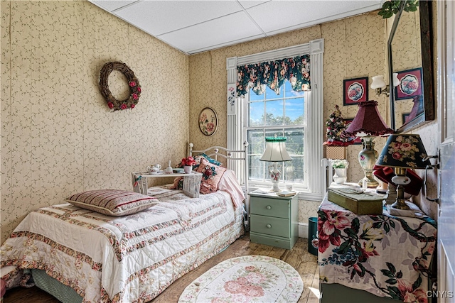 bedroom with wood-type flooring and a paneled ceiling