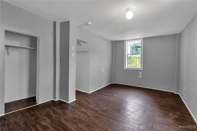 unfurnished bedroom with a closet and dark hardwood / wood-style floors