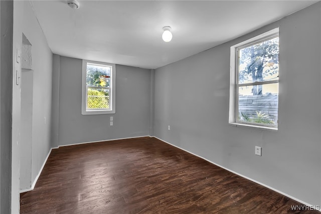 empty room featuring dark hardwood / wood-style floors and plenty of natural light