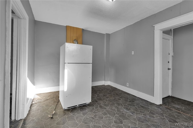 kitchen with a textured ceiling and white fridge