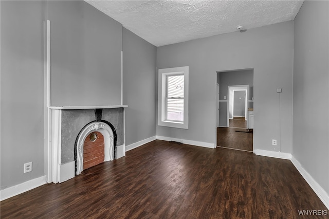 unfurnished living room featuring a textured ceiling and dark wood-type flooring