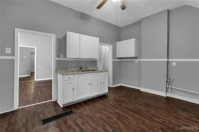 kitchen with white cabinets, a textured ceiling, sink, and dark hardwood / wood-style flooring